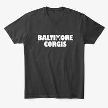 A photo of black tee shirt that has a white Baltimore Corgis logo.